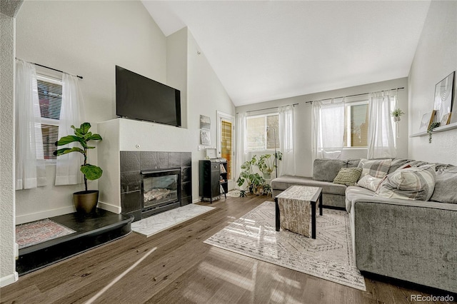 living room featuring hardwood / wood-style flooring, a fireplace, and high vaulted ceiling