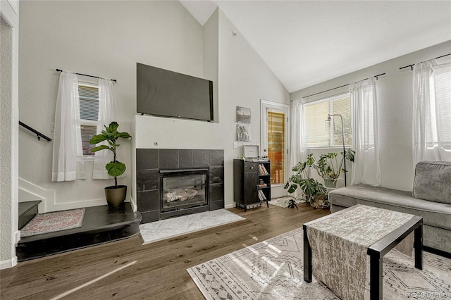 970 S Dawson Way Unit 10, Aurora, CO 80012 - living room featuring wood finished floors, a tile fireplace, high vaulted ceiling, and baseboards