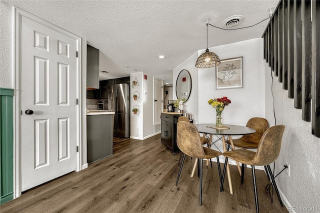 970 S Dawson Way Unit 10, Aurora, CO 80012 - dining space featuring a textured ceiling, dark wood finished floors, baseboards, and stairs