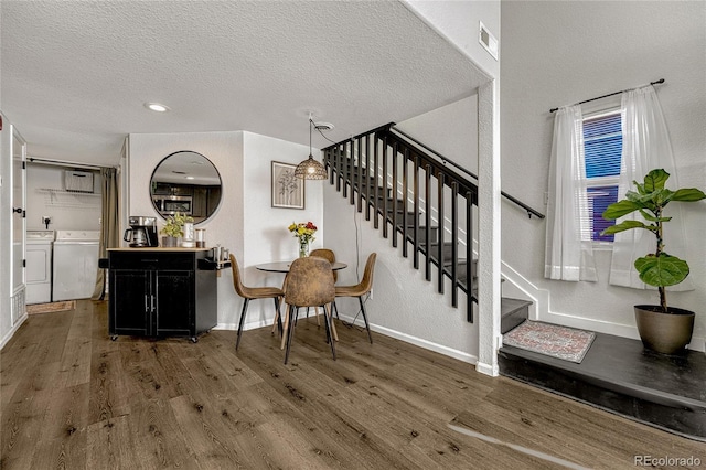 foyer entrance with a textured ceiling, separate washer and dryer, and dark wood-type flooring