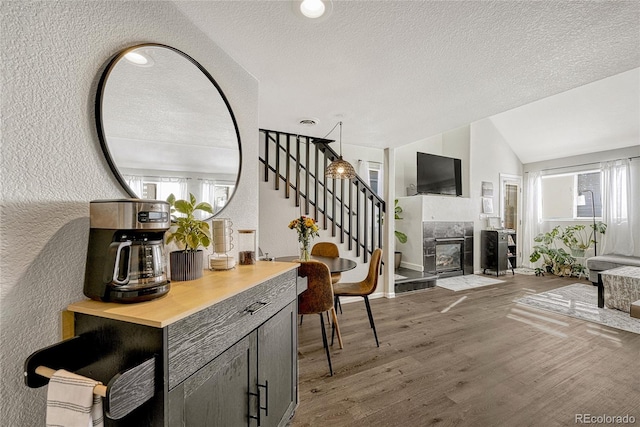 970 S Dawson Way Unit 10, Aurora, CO 80012 - interior space featuring a tile fireplace, stairway, wood finished floors, vaulted ceiling, and a textured wall