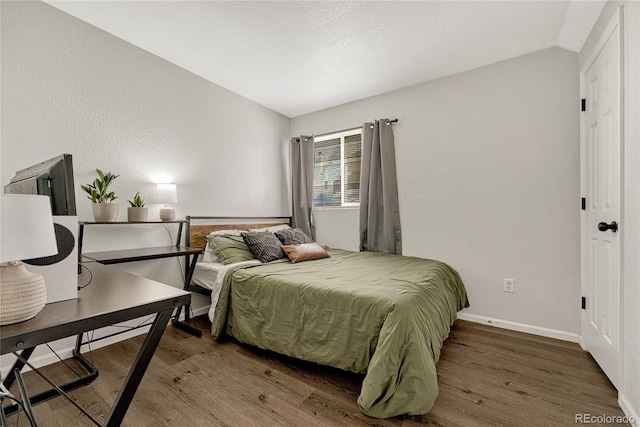 bedroom featuring dark hardwood / wood-style flooring and lofted ceiling