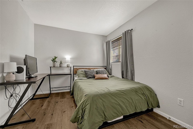 bedroom with hardwood / wood-style flooring and vaulted ceiling