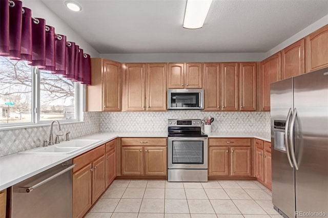 kitchen featuring decorative backsplash, stainless steel appliances, a sink, and light countertops