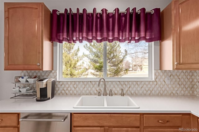 kitchen with dishwasher, light countertops, a sink, and a healthy amount of sunlight