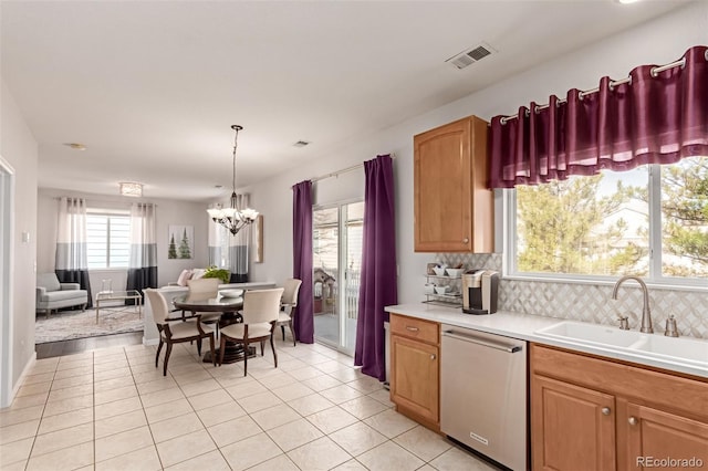 kitchen featuring a sink, visible vents, light countertops, stainless steel dishwasher, and tasteful backsplash