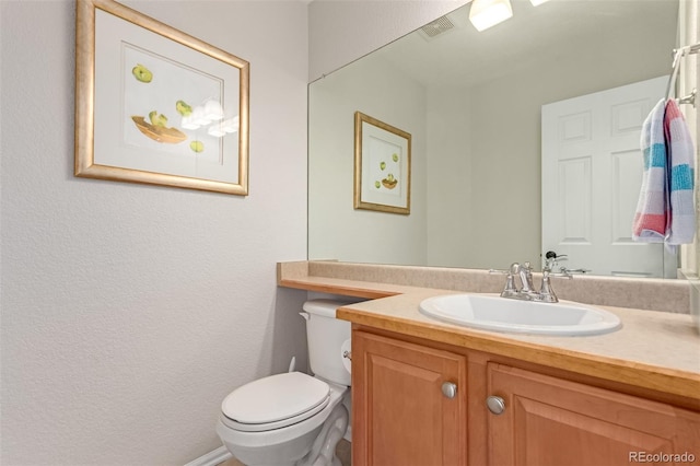 bathroom with visible vents, vanity, and toilet