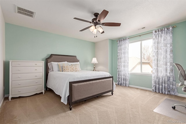 carpeted bedroom featuring a ceiling fan, visible vents, and baseboards