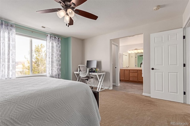 bedroom with visible vents, light carpet, connected bathroom, ceiling fan, and baseboards