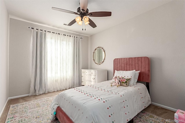 carpeted bedroom with ceiling fan and baseboards