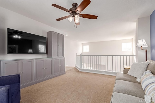 living room with a ceiling fan and light carpet