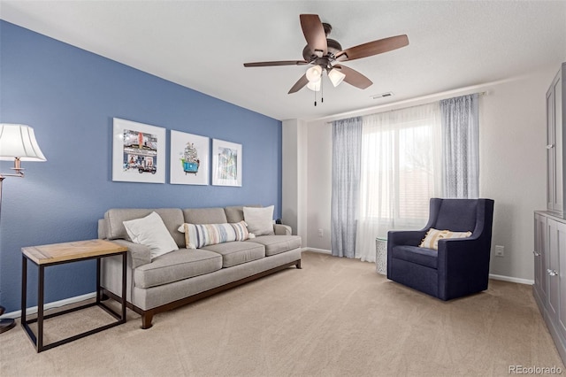 living area with carpet, visible vents, ceiling fan, and baseboards