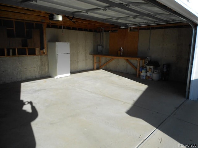 garage featuring white fridge and a garage door opener