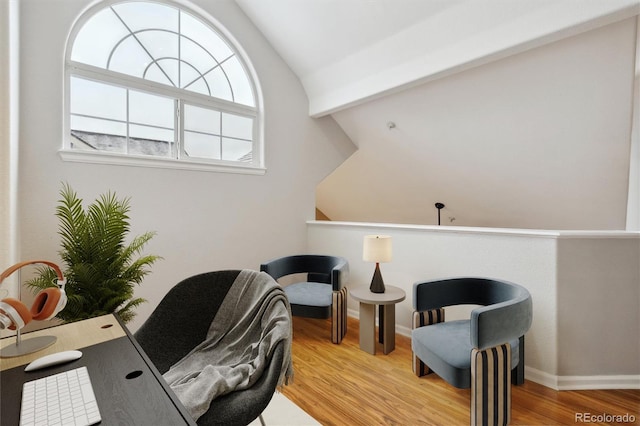 office space featuring baseboards, vaulted ceiling, and wood finished floors