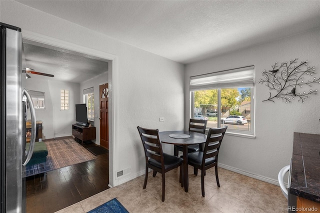 dining room with ceiling fan, plenty of natural light, a textured ceiling, and light hardwood / wood-style flooring