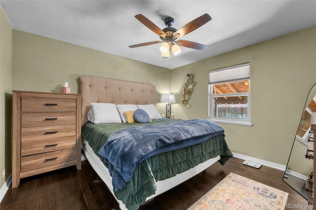 bedroom with a textured ceiling, ceiling fan, and dark hardwood / wood-style flooring