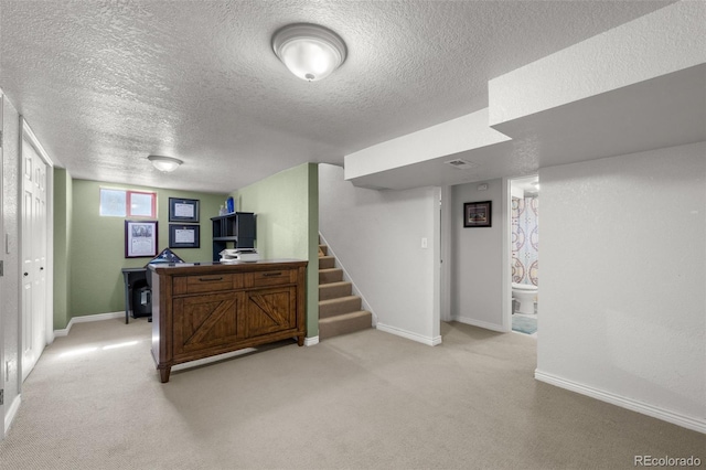 interior space featuring light carpet and a textured ceiling