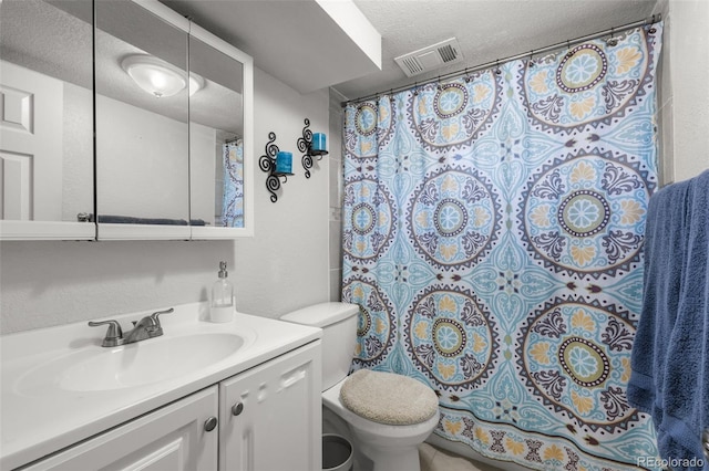 bathroom featuring walk in shower, vanity, toilet, and a textured ceiling