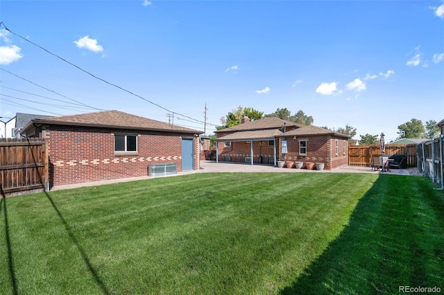 rear view of house featuring a lawn and a patio area