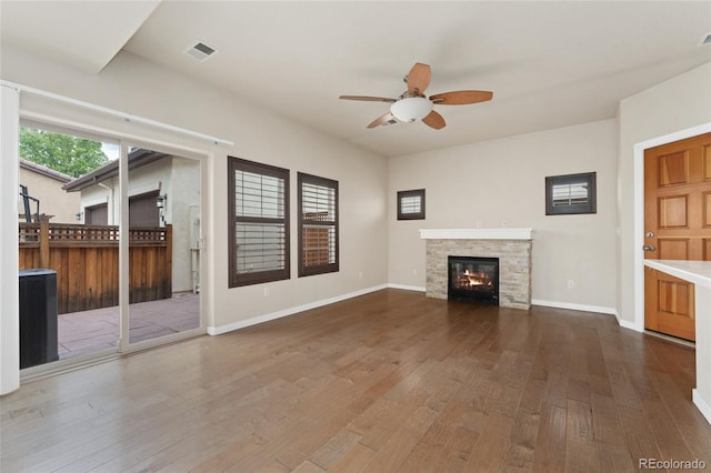 10044 Martin Luther King Blvd, Denver, CO 80238 - unfurnished living room with ceiling fan, dark wood-type flooring, a stone fireplace, and baseboards
