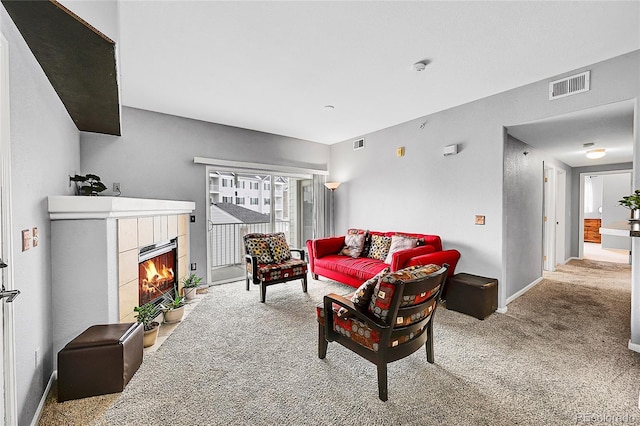 living area with light carpet, a fireplace, and visible vents