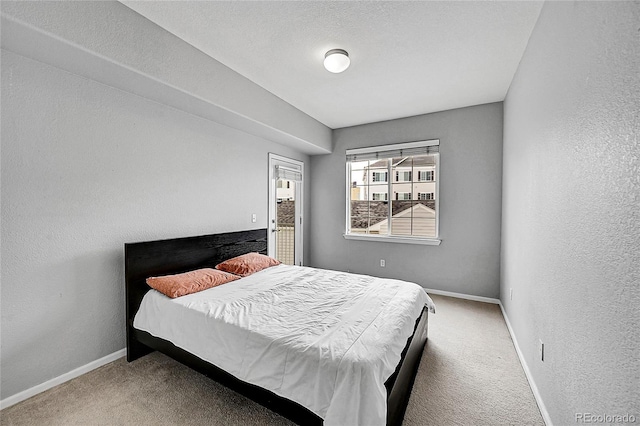 bedroom featuring carpet floors, baseboards, and a textured wall