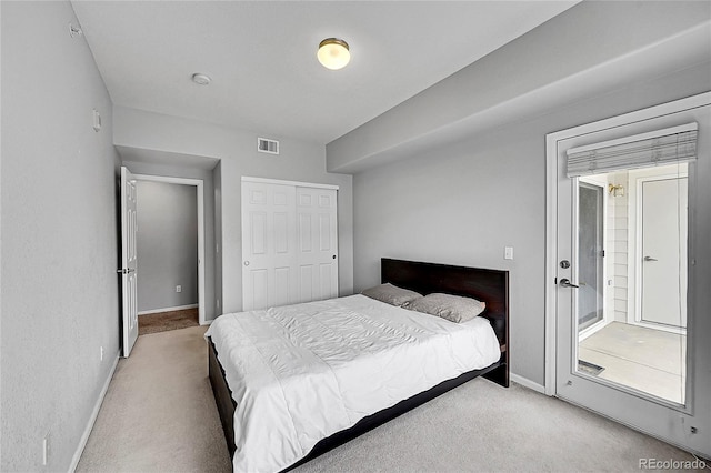 bedroom with a closet, visible vents, light carpet, and baseboards