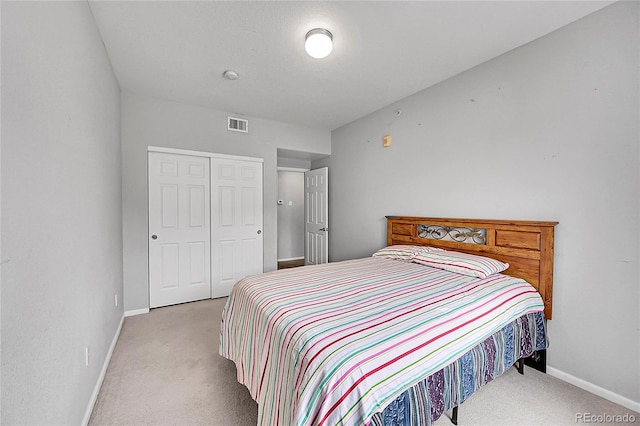 bedroom featuring a closet, light colored carpet, visible vents, and baseboards