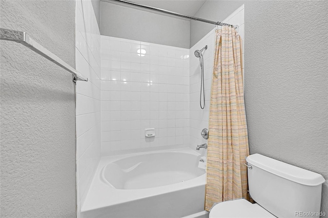 full bath with a textured wall, shower / bath combo with shower curtain, and toilet