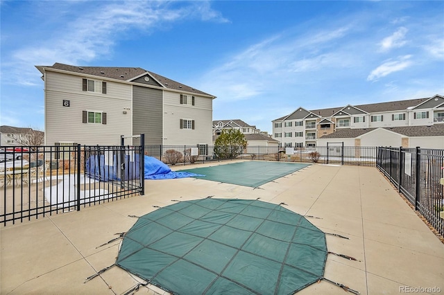 pool with a patio area, a residential view, and fence