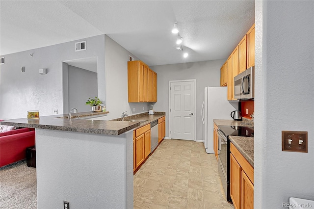 15700 E Jamison Dr Unit 6-201, Englewood, CO 80112 - kitchen with visible vents, a peninsula, a textured ceiling, a sink, and stainless steel appliances
