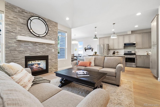 863 Shirttail Peak Dr, Windsor, CO 80550 - living room featuring light wood finished floors, a fireplace, and recessed lighting