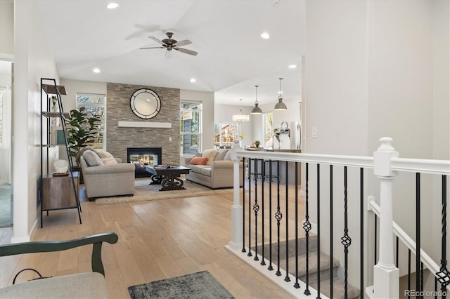 863 Shirttail Peak Dr, Windsor, CO 80550 - living area with a multi sided fireplace, lofted ceiling, ceiling fan, wood-type flooring, and recessed lighting
