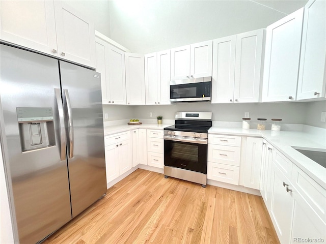 kitchen featuring appliances with stainless steel finishes, light wood-type flooring, light countertops, and white cabinetry