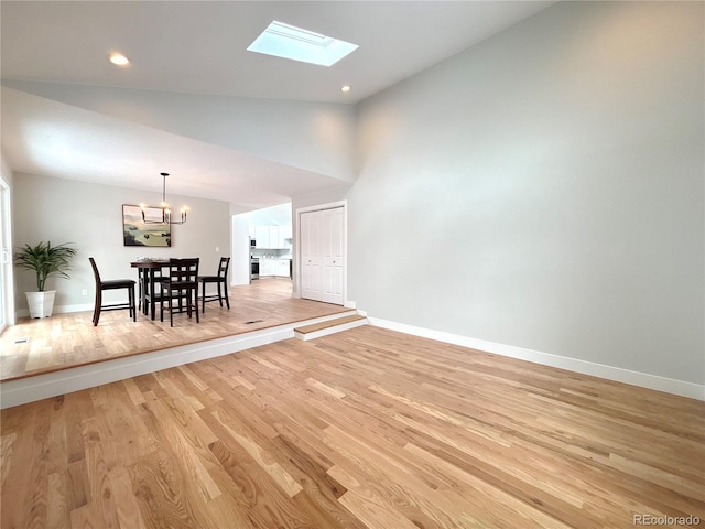 dining space featuring light wood finished floors, an inviting chandelier, and baseboards