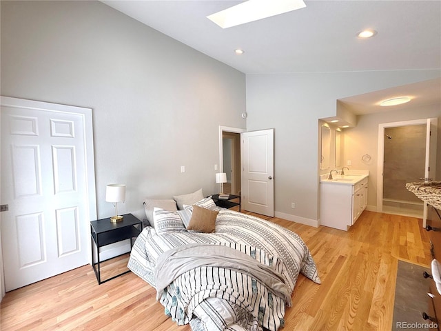 bedroom with baseboards, vaulted ceiling with skylight, recessed lighting, and light wood-style floors