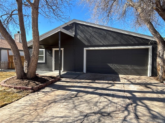 view of front of home featuring concrete driveway, fence, and an attached garage