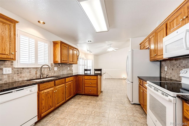 kitchen with tasteful backsplash, dark stone countertops, sink, and white appliances