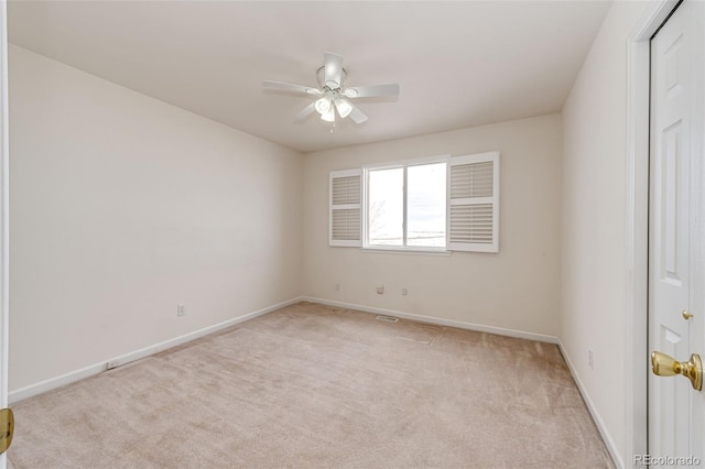 empty room featuring ceiling fan and light colored carpet