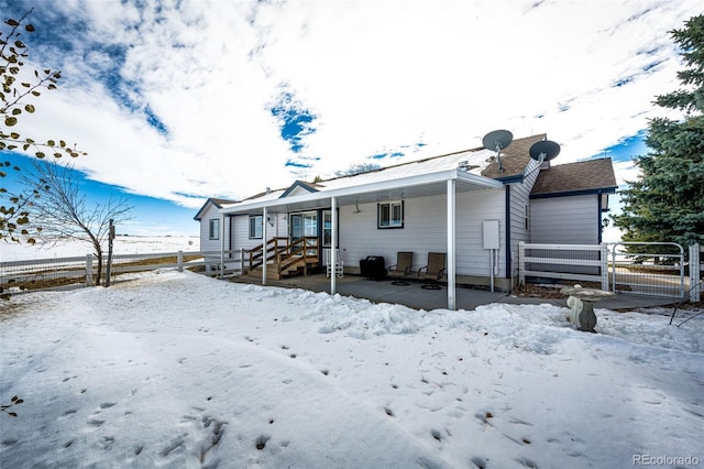 view of snow covered back of property