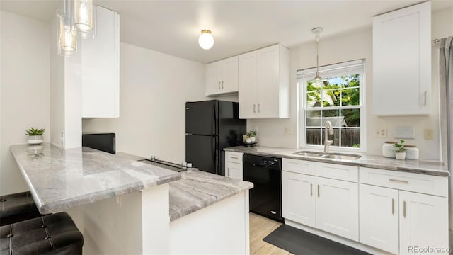 2918 Silverplume Dr Unit C1, Fort Collins, CO 80526 - kitchen with black appliances, a peninsula, light stone counters, white cabinets, and light wood-type flooring