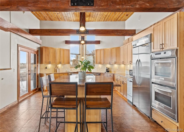 kitchen featuring vaulted ceiling with beams, light brown cabinets, a kitchen island, stainless steel appliances, and backsplash