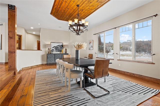 dining room featuring wood ceiling, a chandelier, and light hardwood / wood-style flooring