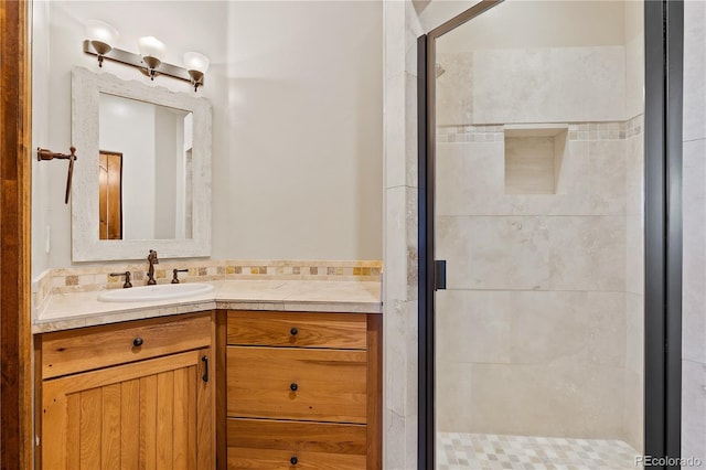 bathroom featuring a shower with door and vanity