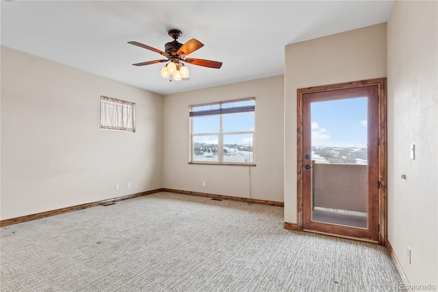 empty room with ceiling fan, light carpet, and a wealth of natural light