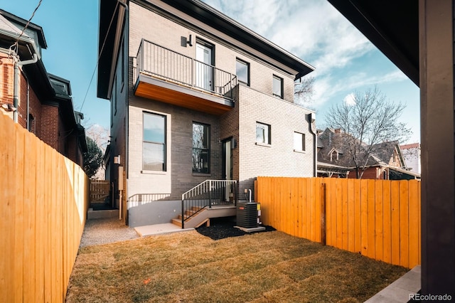 2753 Curtis St, Denver, CO 80205 - back of property with a balcony, a fenced backyard, brick siding, and central AC