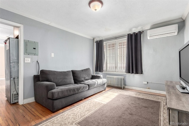 living room featuring a textured ceiling, wood finished floors, radiator, a wall mounted air conditioner, and crown molding