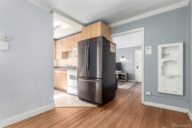 kitchen with ornamental molding, light brown cabinetry, white appliances, and light wood-style flooring