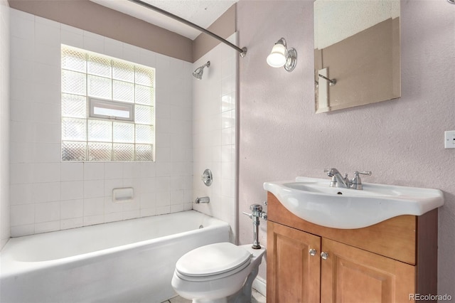 bathroom featuring washtub / shower combination, a textured wall, vanity, and toilet