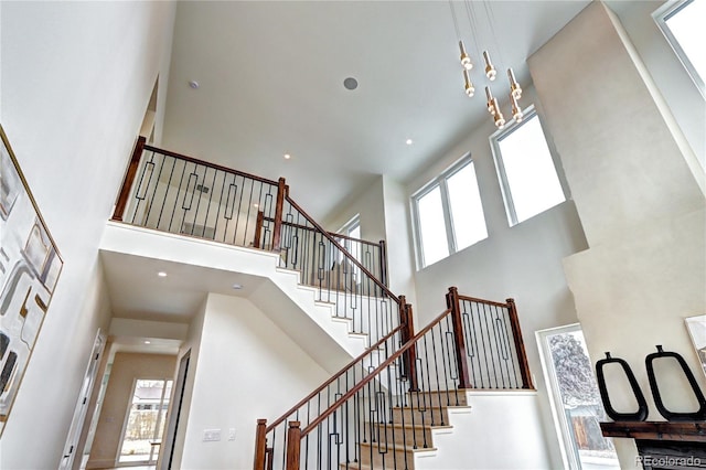 staircase with a high ceiling and a healthy amount of sunlight